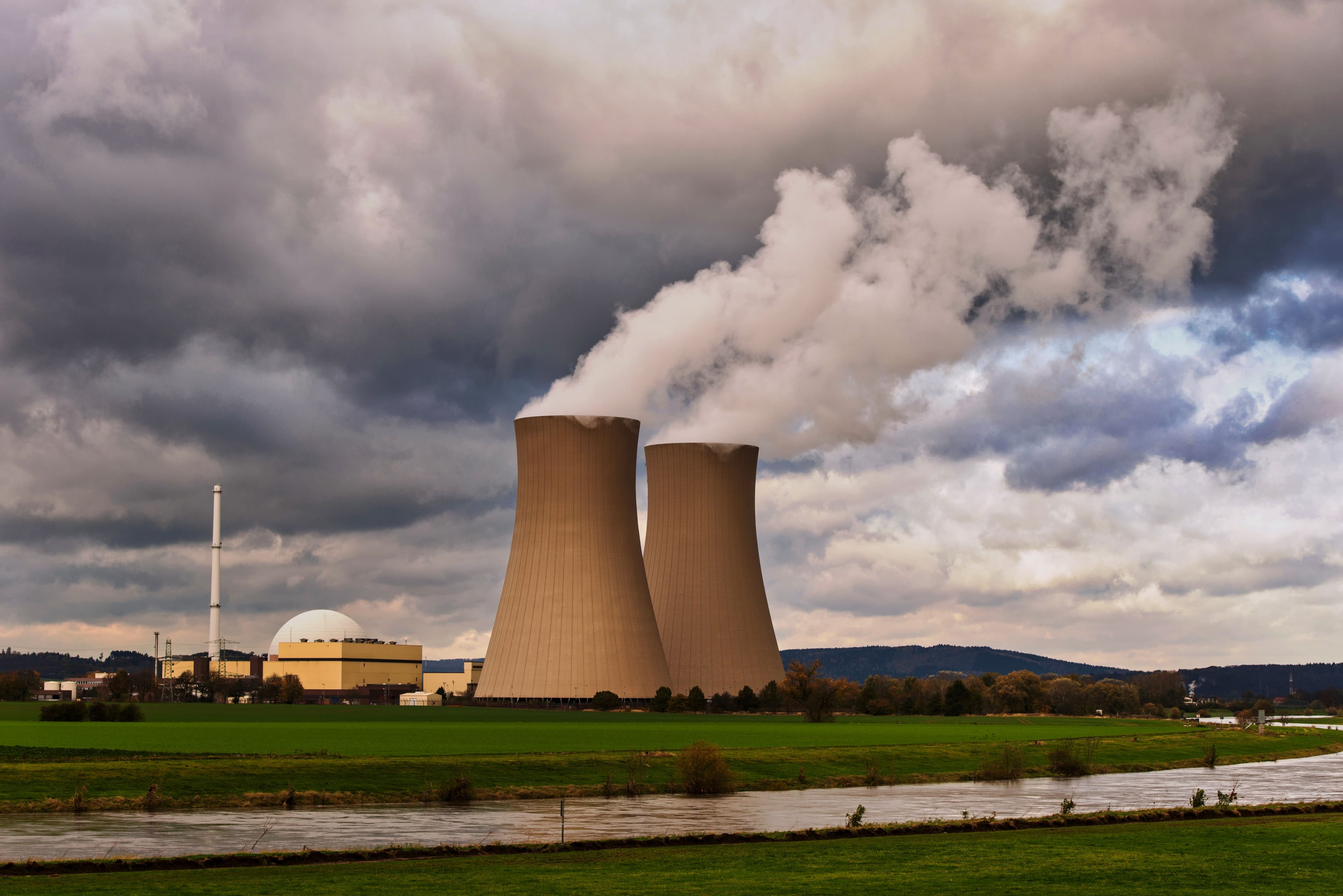 Representative photograph of industrial cooling towers beneath a cloudy sky.